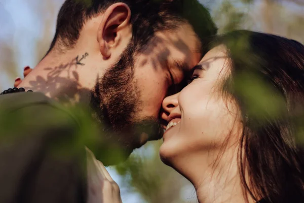 Head shot of young affectionate romantic couple in love. Close up portrait of attractive brunette girl and guy with eyes closed, close to each other. Concept of first kiss, tenderness and amorousness. Art shadow on the face