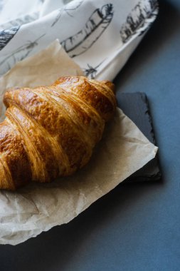 taze pişmiş kruvasan kurutulmuş çiçek ve parşömen gri masada, yakın 