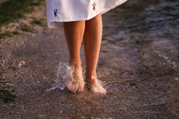 güzel genç brunete kadın sahilde güzel bir görünüm sahiptir ve iyi bir gündoğumu zamanı vardır. Rahatla