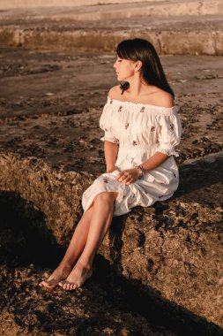 güzel genç brunete kadının saçları sahilde rüzgar gelişir. boho tarzı giysiler giyen model, kız freedoom ve gündoğumu sahiptir