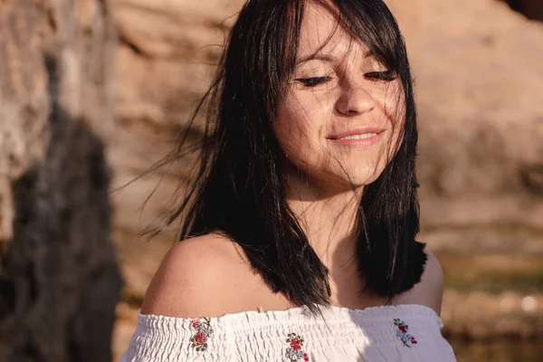 güzel genç brunete kadının saçları sahilde rüzgar gelişir. boho tarzı giysiler giyen model, kız freedoom ve gündoğumu sahiptir