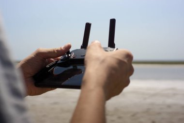 young beautiful man controling a drone.