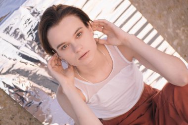 Gün doğumunda folyolu güzel bir kadının moda fotoğraf çekimi. Vogue tarzı konsept.