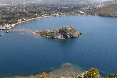 Gümüşlük Körfezi 'nde Tavşan Adası 'nın havadan yüksek açı görünümü, Bodrum. Türkiye 'de bir sahil köyü ve balıkçılık limanı olan Gümüşlük, Myndos antik kentinin kalıntıları üzerinde yer almaktadır.