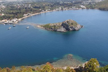 Gümüşlük Körfezi 'nde Tavşan Adası 'nın havadan yüksek açı görünümü, Bodrum. Türkiye 'de bir sahil köyü ve balıkçılık limanı olan Gümüşlük, Myndos antik kentinin kalıntıları üzerinde yer almaktadır.