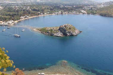 Gümüşlük Körfezi 'nde Tavşan Adası 'nın havadan yüksek açı görünümü, Bodrum. Türkiye 'de bir sahil köyü ve balıkçılık limanı olan Gümüşlük, Myndos antik kentinin kalıntıları üzerinde yer almaktadır.