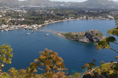 Gümüşlük Körfezi 'nde Tavşan Adası 'nın havadan yüksek açı görünümü, Bodrum. Türkiye 'de bir sahil köyü ve balıkçılık limanı olan Gümüşlük, Myndos antik kentinin kalıntıları üzerinde yer almaktadır.
