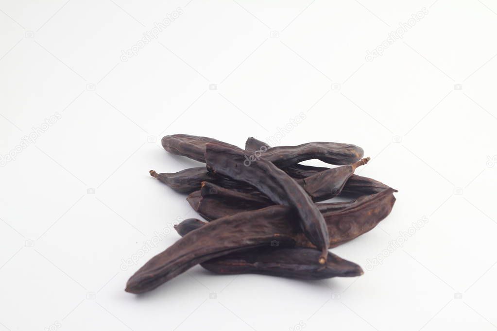 Carob on white background. Organic carob pods with seeds