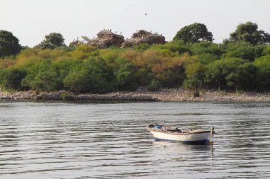 yalnız balıkçı teknesi sakin göle demirledi. durgun bir göl suyunda ahşap balıkçı teknesi. kıyıda demirlemiş ahşap balıkçı teknesi görüntü. metin için alan.
