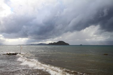 Okyanus üzerinde şiddetli, fırtına bulutları, bir fırtınanın gelişinin habercisi. Çok güzel aydınlatılmış kara bulutlar ve okyanus sularındaki yansımalar.