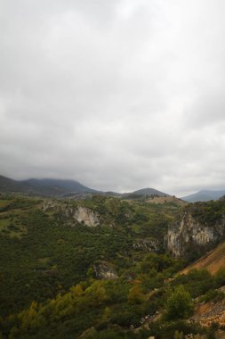 Gün batımında alçak bulutlar, dağlar, deniz ve renkli gökyüzü havadan görünümü. Gün batımında bulutların üzerinde. Bulutlu gökyüzü ve kayalar ile Amazing manzara. Doğa arka planı
