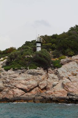 Fırtınalı bulutlu gün. Dramatik gökyüzü ve deniz feneri, büyük dalgalar