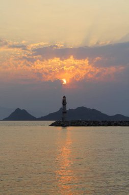 Gün batımında deniz manzarası. Sahilde deniz feneri. Turgutreis sahil kasabası ve muhteşem gün batımı