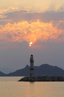 Gün batımında deniz manzarası. Sahilde deniz feneri. Turgutreis sahil kasabası ve muhteşem gün batımı