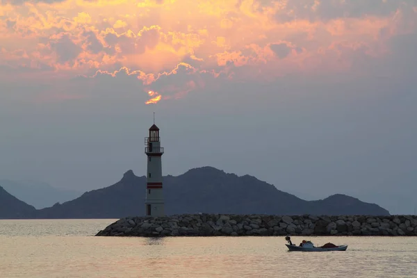 Seascape at sunset. Lighthouse on the coast.Seaside town of Turgutreis and spectacular sunsets