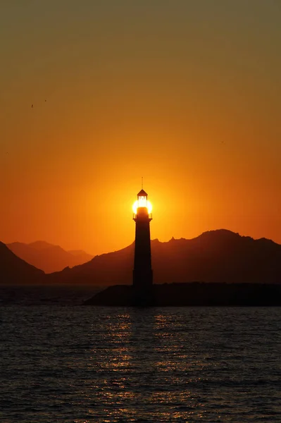 Seascape at sunset. Lighthouse on the coast.Seaside town of Turgutreis and spectacular sunsets