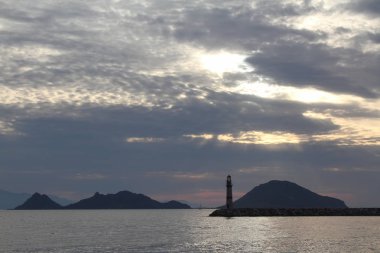 Gün batımında deniz manzarası. Sahildeki deniz feneri. Deniz kenti Turgutreis ve muhteşem gün batımları