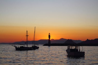 Gün batımında deniz manzarası. Sahildeki deniz feneri. Deniz kenti Turgutreis ve muhteşem gün batımları