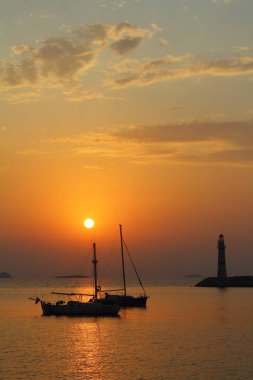 Gün batımında deniz manzarası. Sahildeki deniz feneri. Deniz kenti Turgutreis ve muhteşem gün batımları