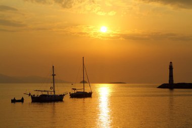 Gün batımında deniz manzarası. Sahildeki deniz feneri. Deniz kenti Turgutreis ve muhteşem gün batımları