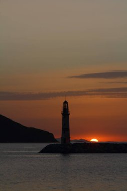 Gün batımında deniz manzarası. Sahildeki deniz feneri. Deniz kenti Turgutreis ve muhteşem gün batımları