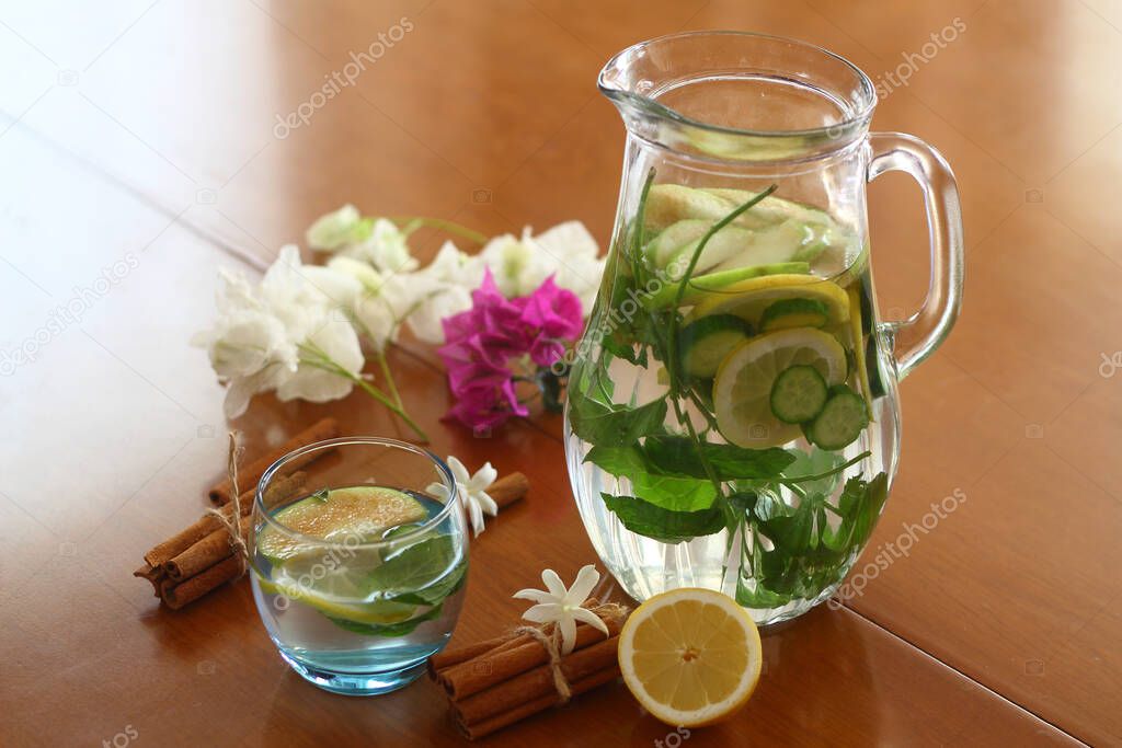 Health care, fitness, healthy eating concept. Fresh cool lemon cucumber drink with water, cocktail, detox drink, lemonade in a glass jug and a glass.