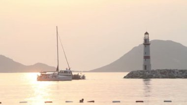 Körfezde bir yelkenli. Denizin üzerinde gün batımı. Turgutreis, Bodrum, Mugla.