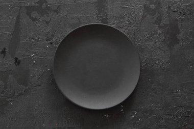 Karanlık taş masada boş siyah levha. Menü için yemek geçmişi, tarif. Masa ayarı. Flatlay, üst manzara. Restoran yemeği için maket.