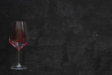 Siyah arka planda bir kadeh kırmızı şarap. düz yat.