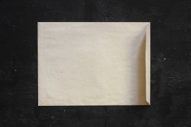 Siyah zemin üzerinde sarı eski kağıt zarflar, düz yatıyordu