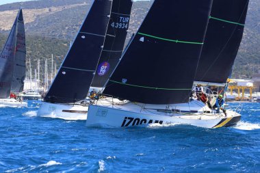 Bodrum, Hindi. 06 Nisan 2024: Ege Denizi 'nin mavi sularında, ünlü tatil beldesi Bodrum' un kıyılarında yelkenliler rüzgarlı havada yelken açıyor.