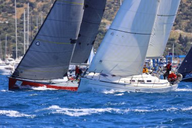 Bodrum, Hindi. 06 Nisan 2024: Ege Denizi 'nin mavi sularında, ünlü tatil beldesi Bodrum' un kıyılarında yelkenliler rüzgarlı havada yelken açıyor.