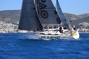 Bodrum, Hindi. 06 Nisan 2024: Ege Denizi 'nin mavi sularında, ünlü tatil beldesi Bodrum' un kıyılarında yelkenliler rüzgarlı havada yelken açıyor.