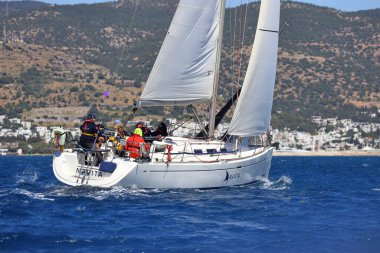 Bodrum, Hindi. 06 Nisan 2024: Ege Denizi 'nin mavi sularında, ünlü tatil beldesi Bodrum' un kıyılarında yelkenliler rüzgarlı havada yelken açıyor.