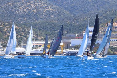 Bodrum, Hindi. 06 Nisan 2024: Ege Denizi 'nin mavi sularında, ünlü tatil beldesi Bodrum' un kıyılarında yelkenliler rüzgarlı havada yelken açıyor.