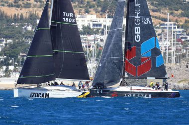 Bodrum, Hindi. 06 Nisan 2024: Ege Denizi 'nin mavi sularında, ünlü tatil beldesi Bodrum' un kıyılarında yelkenliler rüzgarlı havada yelken açıyor.