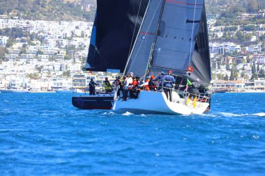 Bodrum, Hindi. 06 Nisan 2024: Ege Denizi 'nin mavi sularında, ünlü tatil beldesi Bodrum' un kıyılarında yelkenliler rüzgarlı havada yelken açıyor.