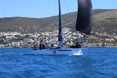 Bodrum, Hindi. 06 Nisan 2024: Ege Denizi 'nin mavi sularında, ünlü tatil beldesi Bodrum' un kıyılarında yelkenliler rüzgarlı havada yelken açıyor.