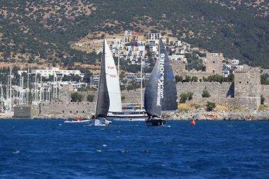 Bodrum, Hindi. 06 Nisan 2024: Ege Denizi 'nin mavi sularında, ünlü tatil beldesi Bodrum' un kıyılarında yelkenliler rüzgarlı havada yelken açıyor.