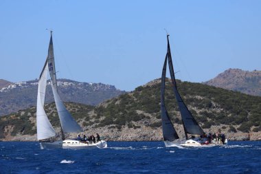 Bodrum, Hindi. 06 Nisan 2024: Ege Denizi 'nin mavi sularında, ünlü tatil beldesi Bodrum' un kıyılarında yelkenliler rüzgarlı havada yelken açıyor.