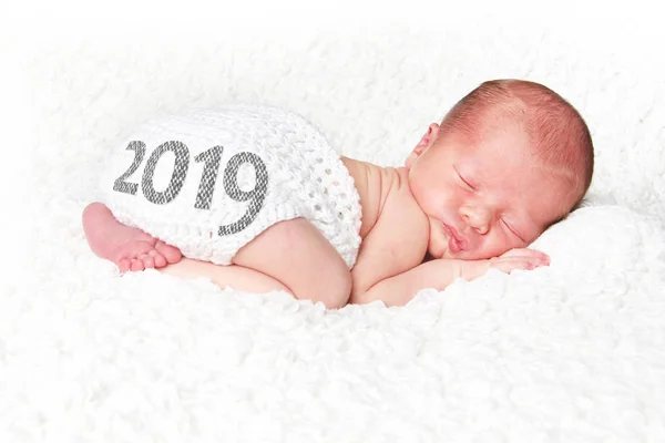 2019 新年あけましておめでとうございますのシルクハットを身に着けている白い毛布で寝ている生まれたばかりの赤ちゃんの肖像画 — ストック写真