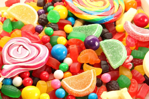 各种甜糖糖果包括棒棒糖 胶质熊 口香糖球和糖果片 糖果平放置背景 图库图片