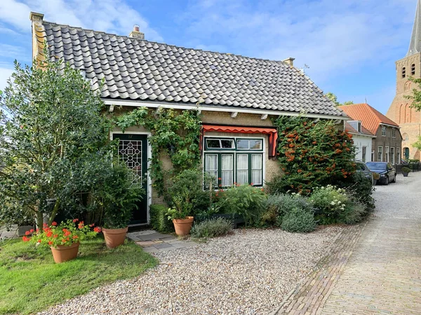 Charmant Nederlands bakstenen huis met de protestantse kerk in de bac — Stockfoto
