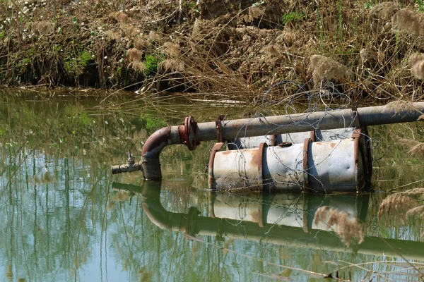 Sewage pipe in the lake on floating barrels — Stock Photo, Image