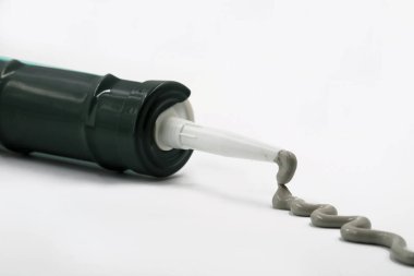 Gri silikon silikon tabanca üzerinde beyaz izole dışında