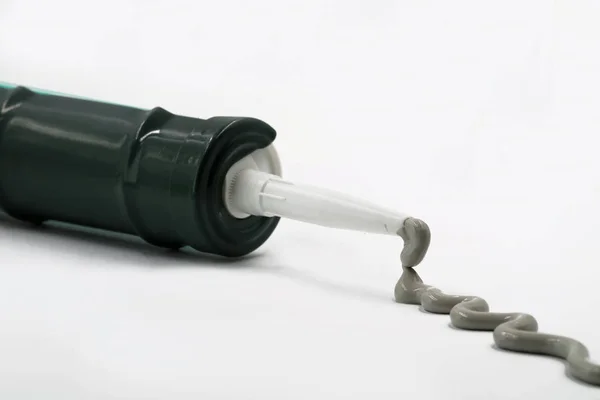 Gri silikon silikon tabanca üzerinde beyaz izole dışında