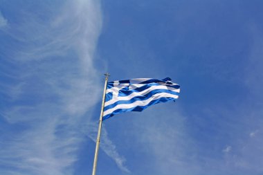 Yunanistan ulusal bayrak mavi gökyüzü önünde sallayarak