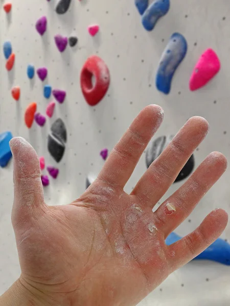 Zbliżenie dłoni rannych mężczyzn głaz z magnezu przed boulderingowa ściana — Zdjęcie stockowe