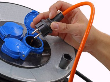 yakın erkek el kablo tambur turuncu kablo takıyor, beyaz arka plan üzerinde elektrik kablosu makara