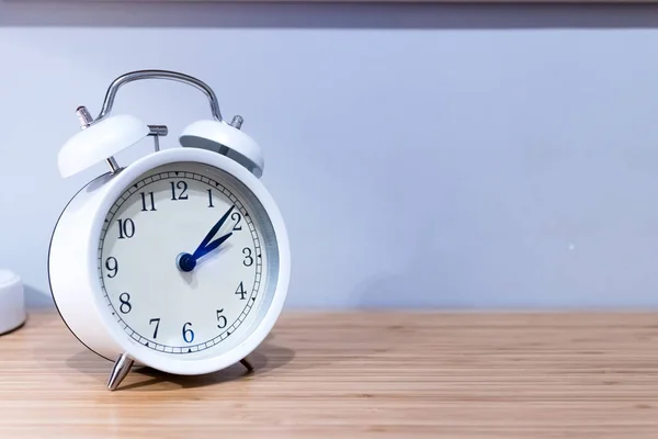 Relógio Alarme Branco Mesa Madeira Com Fundo Parede Azul — Fotografia de Stock